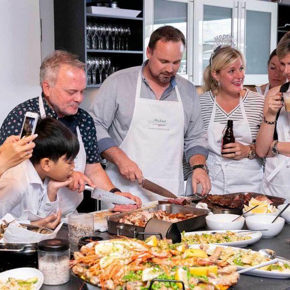 Auf einer privaten Geburtstagsfeier bereiten die Gäste frische Original-Paella zu.