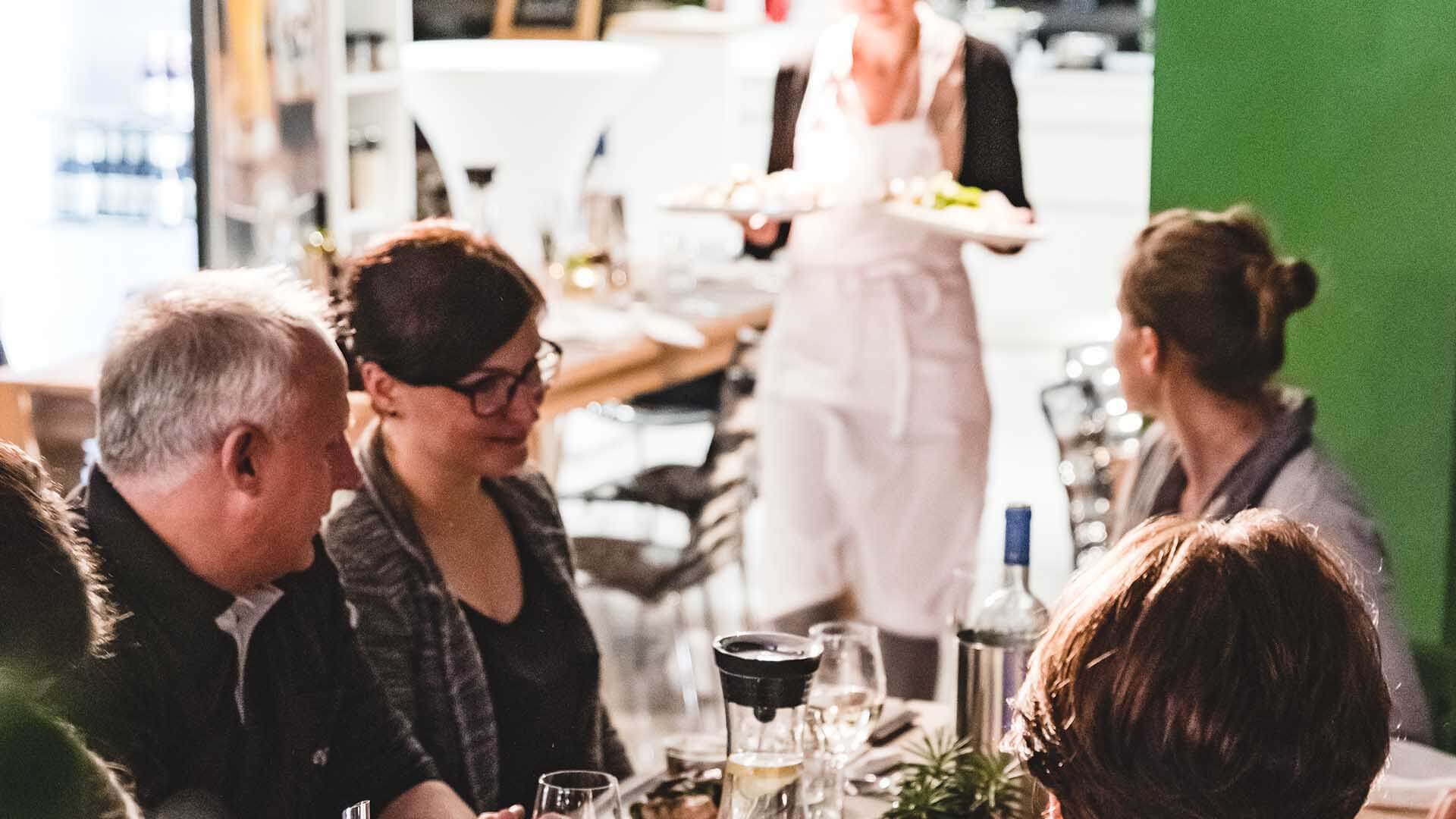Das gemeinsam erstellte Menü beim Team-Format »Kochen aus dem Warenkorb« wird serviert – alle sind gespannt im Kochatelier Köln.